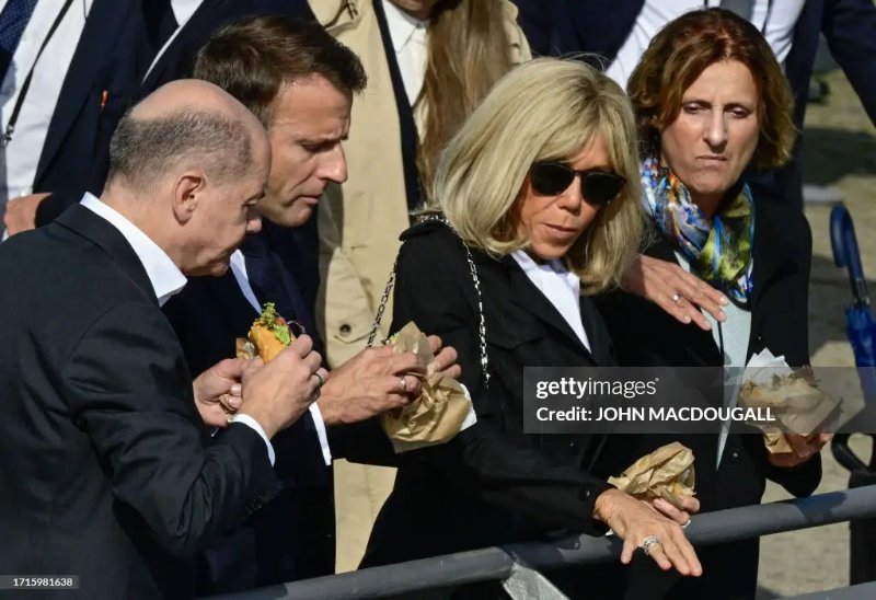 La photo presqu'identique de Getty.<br /><br />Le chancelier allemand Olaf Scholz (à gauche) et son épouse Britta Ernst (à droite), le président français Emmanuel Macron et la première dame française Brigitte Macron (2e à droite) mangent un sandwich au poisson dans un étal de poisson à Hambourg, dans le nord de l’Allemagne, le 10 octobre 2023, au deuxième jour des consultations de deux jours entre les gouvernements franco-allemand. (Photo de John MACDOUGALL / AFP) (Photo de JOHN MACDOUGALL/AFP via Getty Images)<br /><br />Source: https://www.gettyimages.ca/detail/news-photo/german-chancellor-olaf-scholz-and-his-wife-britta-ernst-news-photo/1715981638