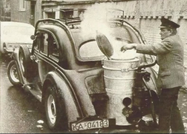 Un homme faisant le plein d’une voiture avec du bois de chauffage dans les années 1940, à une époque où le gaz de bois était utilisé comme alternative à l’essence...<br /><br />Le système de générateur de gaz de bois convertit le bois ou le charbon de bois en gaz de bois, qui peut ensuite être utilisé pour alimenter un moteur à combustion interne. Ces véhicules ont notamment été utilisés pendant la Seconde Guerre mondiale en raison du rationnement du carburant.<br /><br />Le gaz de bois est produit par gazéification de la biomasse à haute température (plus de 700°C). Le gaz produit est un mélange d’azote, de monoxyde de carbone, d’hydrogène et d’autres gaz. Les véhicules au gaz de bois ont été utilisés pour les camions, les bus et même les voitures privées pendant la guerre. Les conducteurs transportaient parfois du bois supplémentaire pour faire le plein pendant les trajets.<br /><br />L’Allemagne comptait plusieurs millions de véhicules fonctionnant au gaz dans les années 1940.<br /><br />Source: https://www.facebook.com/groups/320064400873096/?multi_permalinks=672073812338818