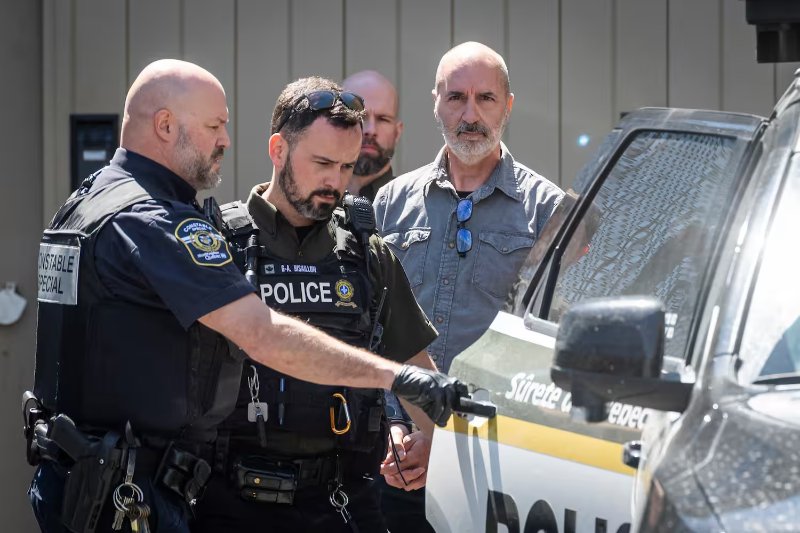 Éric Charbonneau, accompagné de constables et de policiers, à sa sortie du palais de justice de Saint-Hyacinthe après sa sentence pour fabrication et possession d'armes à feu. Photo Agence QMI, Joël Lemay<br /><br />Source: https://www.journaldemontreal.com/2026/06/17/armes-semi-automatiques-et-imprimees-en-3d-larsenal-dun-ex-militaire-de-la-monteregie-lui-vaut-le-penitencier